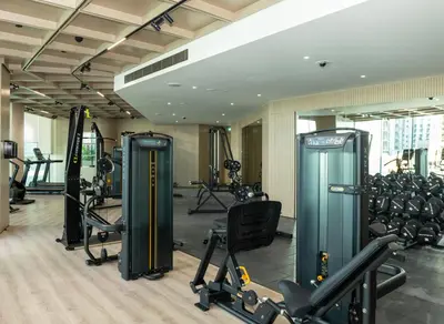 a gym with several treadmills and exercise machines at Spacious and Cozy Apartment - Binghatti Phantom 2404 in Dubai