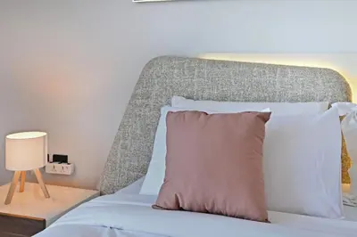 a bedroom with a bed with a headboard at Luxury 1BR at Royal Regency, Refined City Living in Dubai