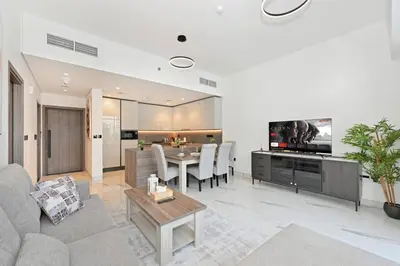a living room with a couch and a table at Luxury 1BR at Royal Regency, Refined City Living in Dubai