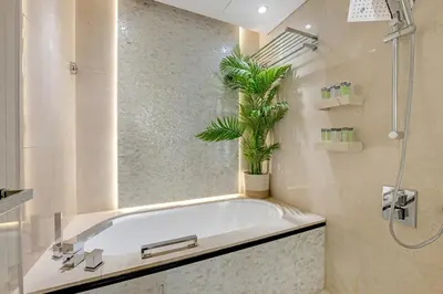 a bathroom with a tub with a plant in it at Waves - JW Marriot Residence Modern & Chic 1BR Apt in Dubai
