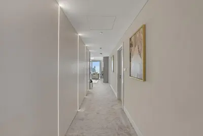 a hallway with white walls and a long hallway with white ceilings at Waves - JW Marriot Residence Modern & Chic 1BR Apt in Dubai