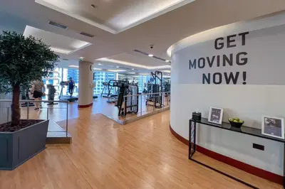 a gym with a sign that says get moving now at Waves - JW Marriot Residence Modern & Chic 1BR Apt in Dubai
