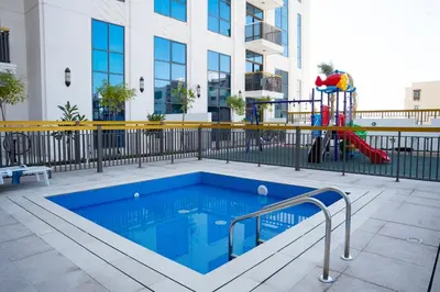 a pool with a slide and a playground in a building at Italian-Design 2BR l Large Private Terrace l Ground Floor in Dubai