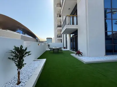 a balcony of a building with a green lawn at Italian-Design 2BR l Large Private Terrace l Ground Floor in Dubai