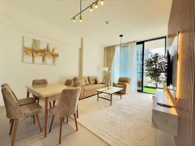 a living room with a table and a couch at Elegant and Stylish Retreat - Lavender Binghatti 1103 in Dubai