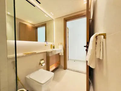 a bathroom with a toilet and a sink and a mirror at Elegant and Stylish Retreat - Lavender Binghatti 1103 in Dubai