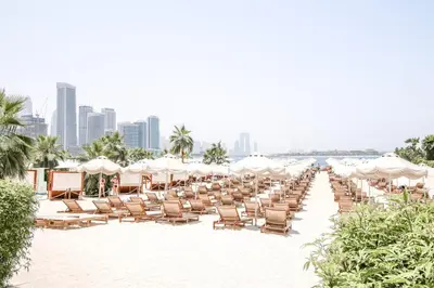 a row of chairs and umbrellas on a beach at Luxury 2BR at Seven Palm Rooftop Pool&Beach Access in Dubai