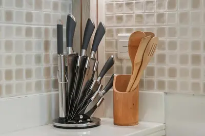 a cup filled with knives and spatulas on a counter at Luxury 2BR at Seven Palm Rooftop Pool&Beach Access in Dubai