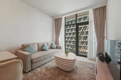 a living room with a couch and a large window at Luxury 2BR at Seven Palm Rooftop Pool&Beach Access in Dubai
