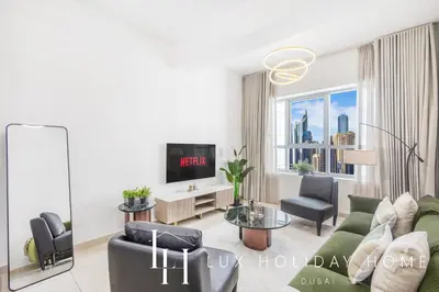 a living room with a couch and a tv at LUX The Armada Suite JLT in Dubai