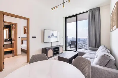 a living room with a couch and a tv at Sleek Modern Home in the Heart of JVC in Dubai