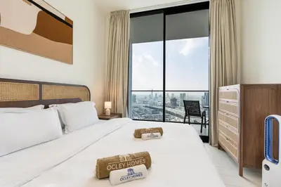 a bedroom with a bed and a large window at Sleek Modern Home in the Heart of JVC in Dubai