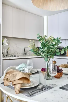 a white kitchen with a table with a plate of bread at Frank Porter - Beach Mansion in Dubai