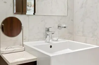 a white bathroom with a sink and a mirror at Bloomfields Tranquil 2BR in Dania 4 in Dubai
