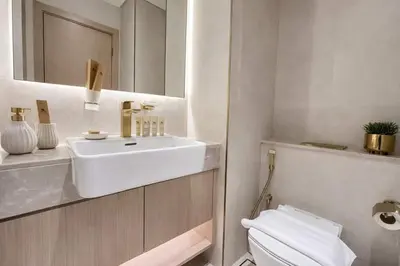 a white bathroom with a sink and a toilet at Contemporary Studio with Premium Design in JVC in Dubai