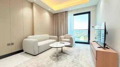 a living room with a couch and a tv and a table at Cloud Tower 1br With Parking Pool Gym & Sports Facilities in Dubai