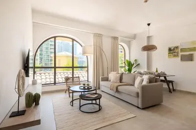 a living room with a couch and a table at Upgraded apartment just steps away from JBR beach in Dubai