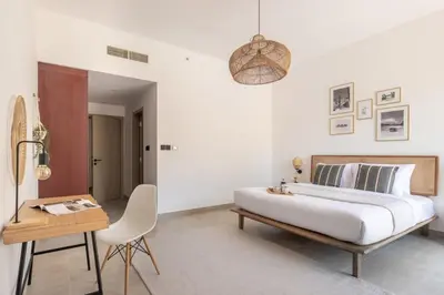a bedroom with a bed and a table and a chair at Upgraded apartment just steps away from JBR beach in Dubai