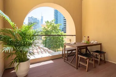 a table and chairs in a room with a window at Upgraded apartment just steps away from JBR beach in Dubai