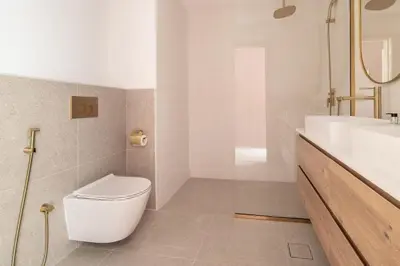 a white bathroom with a toilet and a sink at Upgraded apartment just steps away from JBR beach in Dubai