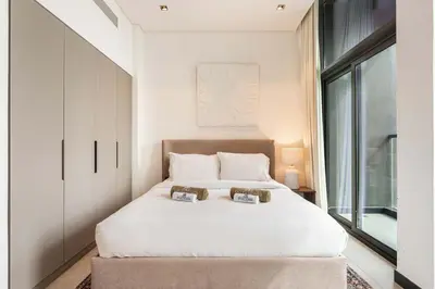 a bedroom with a white bed and a window at Central Modern Studio with Floor to Ceiling Windows in Dubai