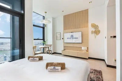 a hotel room with a bed and a tv at Central Modern Studio with Floor to Ceiling Windows in Dubai