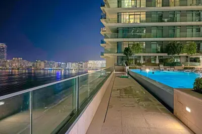 a swimming pool on the side of a building at Miami Vibes - 1BR with Private Beach, Sea, Palm View in Dubai