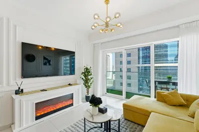 a living room with a couch and a fireplace at Luxury 1BR on Marina Walk, Sea & Palm View-6 Sleep in Dubai
