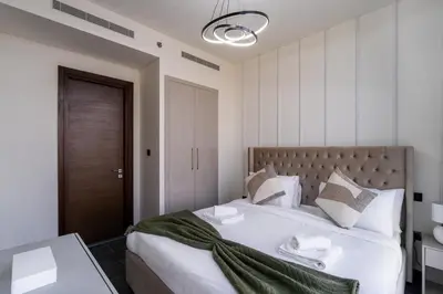 a bedroom with a large white bed and a table at 1BR plus Study Peaceful, Family-Friendly Community in Dubai