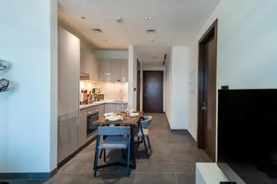 a kitchen and dining room with a table and chairs at 1BR plus Study Peaceful, Family-Friendly Community in Dubai