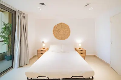 a white bedroom with a bed and a window at Newly renovated, near the beach, with a Marina View in Dubai