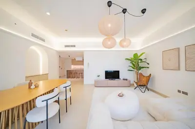 a dining room and living room with a table and chairs at Newly renovated, near the beach, with a Marina View in Dubai