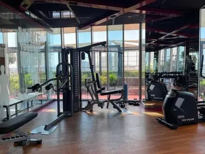 a gym with treadmills and ellipticals in a room with windows at Miracle View in Dubai
