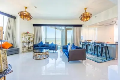 a living room with blue couches and a bar at Miracle View in Dubai