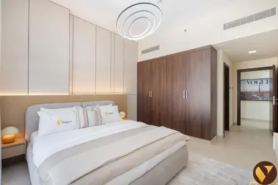a bedroom with a large bed and a brown cabinet at Vogue JVC Jeewar Tower near Circle Mall, One Bedroom Apartment with Balcony and City View, Access to all Amenities in Dubai