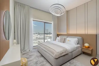 a bedroom with a large bed and a large window at Vogue JVC Jeewar Tower near Circle Mall, One Bedroom Apartment with Balcony and City View, Access to all Amenities in Dubai