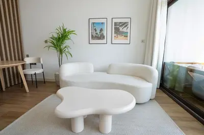a living room with two white chairs and a table at Palm Jumeirah gem with direct beach access in Dubai