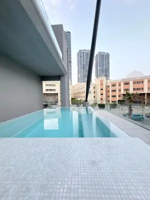 a swimming pool in a building with a city in the background at Modern 2BR House , Pool , 3 Baths, Balconies in Dubai