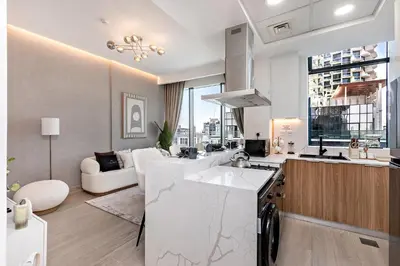 a kitchen and living room with a sink and a couch at Wonderful 1BR Apartment at East Crest in Dubai