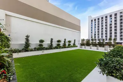 an internal courtyard of a building with a green lawn at Wonderful 1BR Apartment at East Crest in Dubai