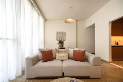 a living room with a couch with pillows on it at Seraya Residences at Downtown Views 1 in Dubai