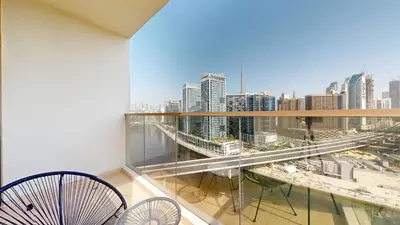 a balcony with two chairs and a view of a city at Elegant 2BR Canal & Burj Khalifa View 1 in Dubai