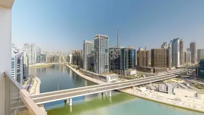 a bridge over a river in a city with buildings at Elegant 2BR Canal & Burj Khalifa View 1 in Dubai