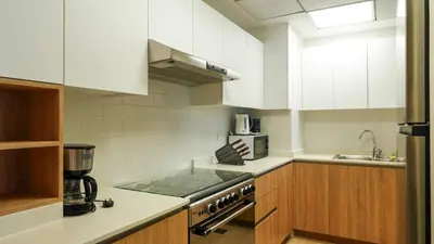 a kitchen with white cabinets and a stove top oven at Modern 3BR Full Canal & Burj Khalifa View 2 in Dubai
