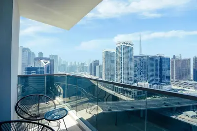 a balcony with chairs and a view of a city at Stunning 2BR Canal View & Burj Khalifa 3 in Dubai
