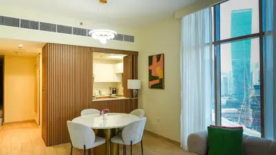 a dining room with a table and chairs and a large window at Stunning 2BR Canal View & Burj Khalifa 3 in Dubai