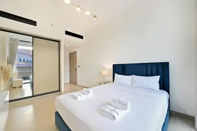 a bedroom with a large bed with two towels on it at Stunning 1 br modern luxury residence at JVC in Dubai