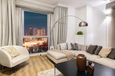 a living room with a couch and a large window at Burj Khalifa and Fountain View 3BR in Dubai