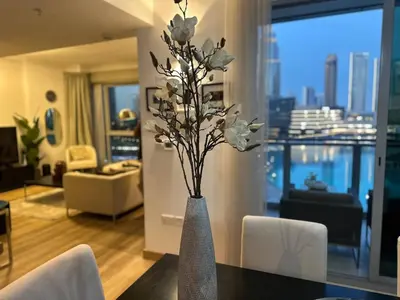 a vase with white flowers on a table in a living room at Burj Khalifa and Fountain View 3BR in Dubai