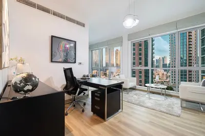 an office with a desk and a room with large windows at Burj Khalifa and Fountain View 3BR in Dubai